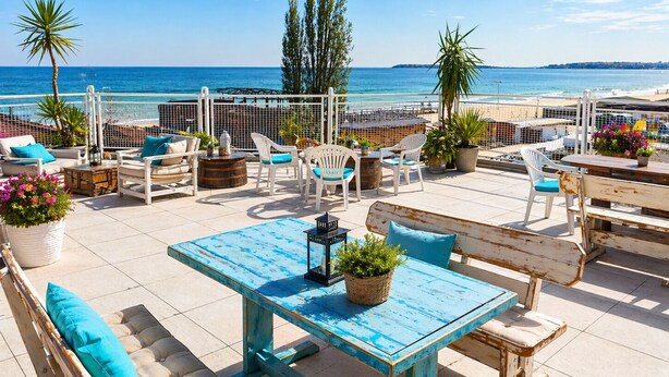 A terrace with outdoor seating, a table, and potted plants. - Largo Beach Hotel (Sunny Beach)