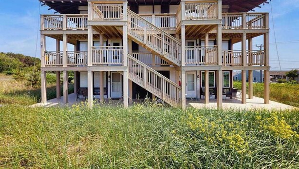 A multi-story building with balconies, a staircase, and a flat roof.