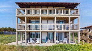 A two-story building with balconies, large windows, and outdoor seating.