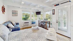 A bedroom with a bed, a desk, a chair, and a window with a view.