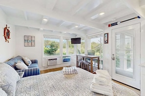 A bedroom with a bed, a desk, a chair, and a window with a view. - Newly Renovated Studio with AC, Grill – steps from Private Beach (Truro)