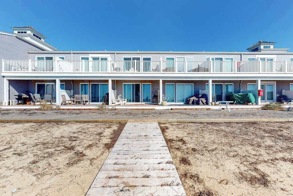 Un hotel sulla spiaggia con un vialetto lungo e stretto che porta a una galleria coperta.
