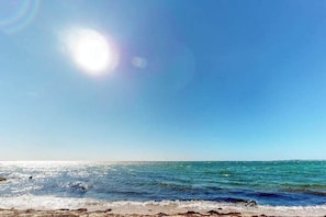 Una playa con cielos despejados y agua tranquila.