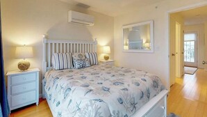 Una camera da letto con un letto, comodini, uno specchio e un condizionatore d'aria.
