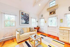 Ein Wohnzimmer mit einer Couch, einem Couchtisch und Kunstwerken an der Wand.
