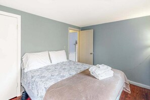A bedroom with a bed, a door, and a wall. - Dog-Friendly Home w/Yard, Deck, Free WiFi, New Gas Grill - Walk to the Beach (Chatham)