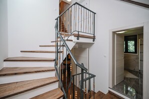 Eine Treppe mit Holzbodenstufen und einem Metallgeländer mit Holzakzenten.