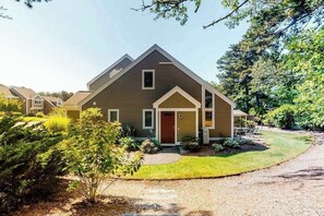 A two-story house with a front porch, a garage, and a well-maintained lawn.