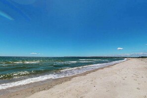 A beach with clear skies and calm waves. - Coastal home with screened porch, W/D, & amazing location (Centerville)