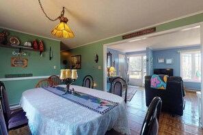A dining area with a table set for four, chairs, a hanging lamp, and a sign that reads 'Faith, Family, Friends.' - Bright & nautical beach home with enclosed yard & outdoor shower - walk to beach (Dennis Port)