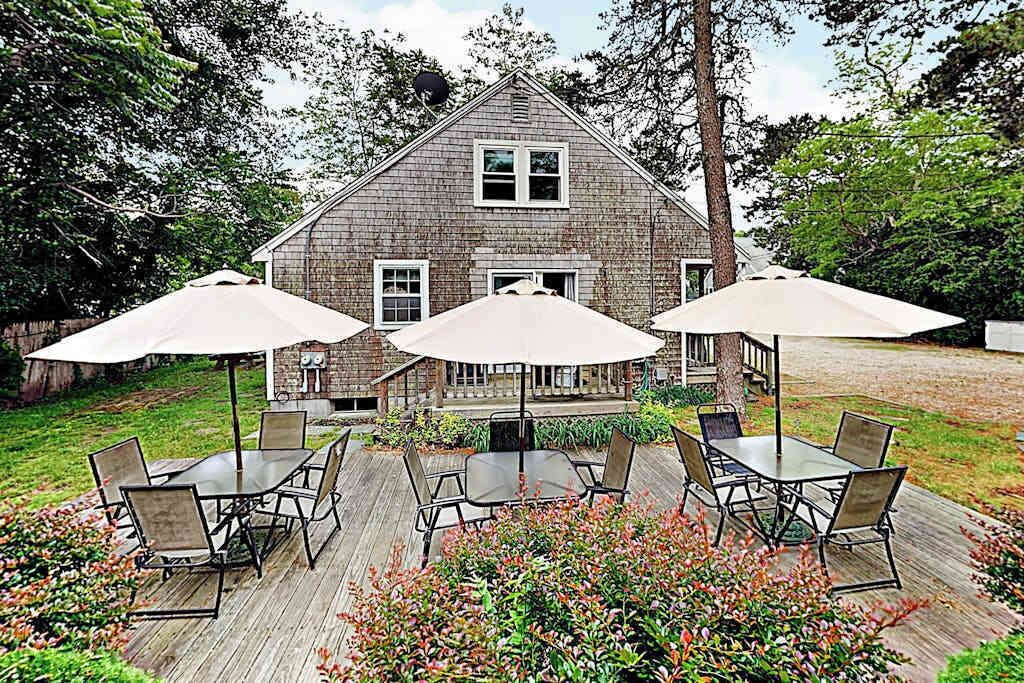 Een huis met een terras, buitenmeubilair en een schotelantenne.