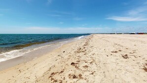 Una playa con cielo despejado y mar tranquilo.