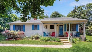 A single-story house with a porch, a front door, and a small garden area.