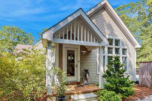 A house with a front porch, a small tree, and a wooden fence. - Peaceful home convenient to bike path, beaches, shopping, dining & entertainment (East Falmouth)