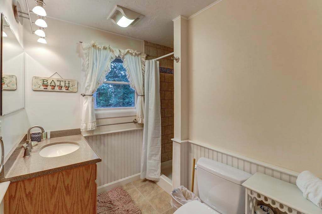 A bathroom with a sink, toilet, and shower area.