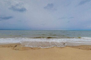 A beach with waves, a clear sky, and a calm sea. - Dog-friendly home with large yard - walk to Great Pond & Kingsbury Beach (Eastham)