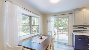 A dining area with a table, chairs, and a view of the outdoors. - Centrally located home near Nauset Light, Coast Guard Beach & Cape Rail Trail (Eastham)
