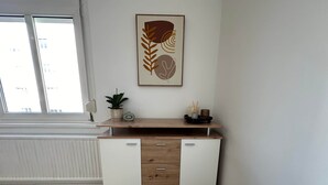 A modern kitchen with a wooden countertop, two white cabinets, a potted plant, and a framed artwork on the wall. - Cozy Studio in Vienna – Great Value Stay (Vienna)