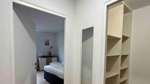 A room with a bed, a desk, and a wardrobe. - Cozy Studio in Vienna – Great Value Stay (Vienna)