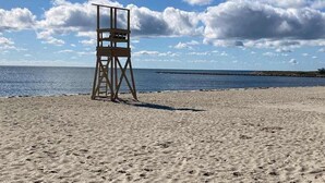 A lifeguard tower on a sandy beach with a clear sky and calm sea. - Peaceful perch near area's beaches with firepit, grill, streaming - dog-friendly (Harwich)