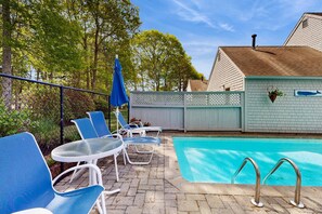 Ein Swimmingpool mit Liegestühlen und einem Zaun.