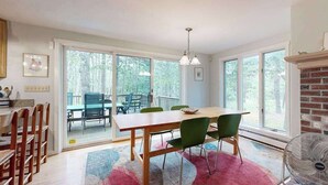 Un coin repas avec une table et des chaises, un ventilateur et une cheminée.