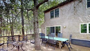 Une terrasse dotée de mobilier d’extérieur, d’une grande fenêtre et d’un arbre.