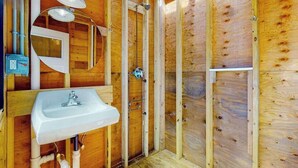 Interior de fusta amb un rentaplat, un mirall i una dutxa.