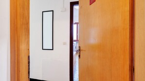 A hallway with a wooden door marked '601', a white wall, and a framed picture.