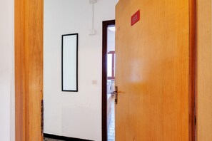 Ein Korridor mit einer Holztür, auf der '601' steht, einer weißen Wand und einem gerahmten Bild.