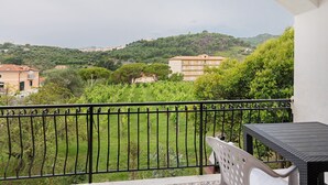 Un balcone con vista su un paesaggio verde e edifici.