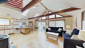 A spacious living area with a kitchen, a dining table, and a sofa.