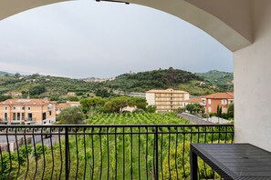 A balcony with a view of a hillside, buildings, and a road. - Apartment '606' with Private Terrace and Shared Garden (Diano Castello)