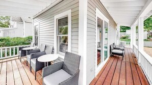Un porche techado con muebles de mimbre y una terraza de madera.