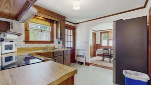 Una cocina con microondas, estufa y armarios de madera.