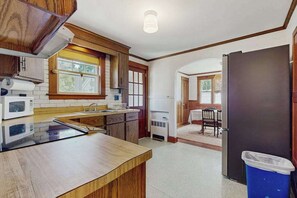 A kitchen with a microwave, stove, and wooden cabinets.