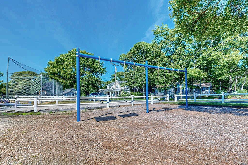 Ein Spielplatz mit einer blauen Schaukel und einem eingezäunten Bereich.