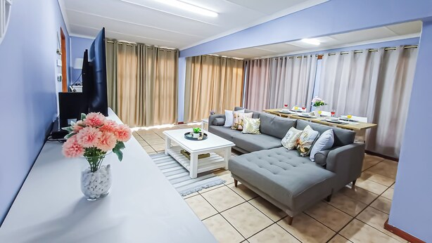 Una sala de estar moderna con un sofá, una mesa de centro y un televisor.
