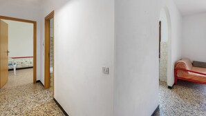 A hallway with a bed, a door, and a light fixture. - Apartment '607' with Private Terrace and Shared Garden (Diano Castello)