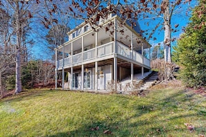 A two-story house with a balcony, a front porch, and a staircase leading to the entrance.