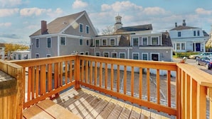 A multi-story building with a wooden deck and a clear view of the surrounding area. - Historic District Hideaway with Home Office | Walk to Commercial St & Pier (Provincetown)