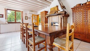 Ein Esszimmer mit einem großen Holztisch, Stühlen und einem Kamin.