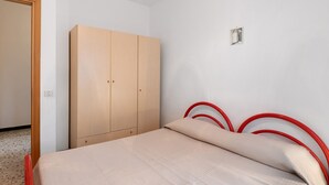 Una camera da letto con un letto, un armadio e una porta.