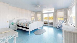 Un dormitorio con cama, mesita de noche, silla y ventana con vistas.