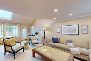 A spacious living room with a sofa, armchairs, a coffee table, and a lamp. - Private pool close to beach with cabana, grill, AC, patio, dog-friendly (Mashpee)