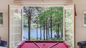Ein Billardtisch mit Blick auf einen See und Bäume.