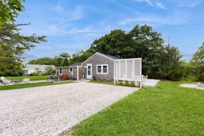 Ein Haus mit Kiesweg, Rasen und Holzzaun.