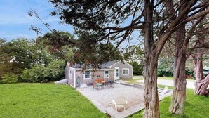 Una casa con patio, prato e alberi.