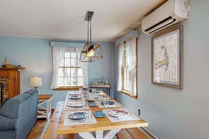 Ein Essbereich mit Holztisch, gedecktem Tisch und einer Leuchte sowie einer Karte an der Wand.