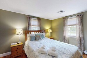 Ein Schlafzimmer mit einem Bett, zwei Nachttischen und Vorhängen.